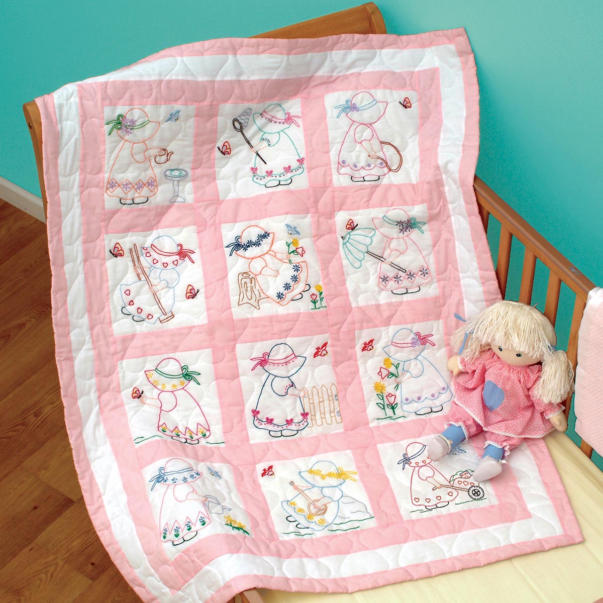Pink and pastel quilt blocks designed for a baby girl's nursery, showcasing floral motifs and classic patchwork.